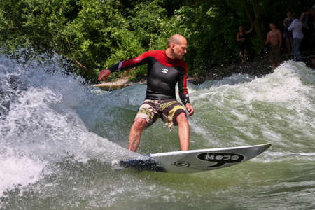 Munich, Germany - July 13, 2019: Surfer in the city river, Munich is famous for people surfing in...
