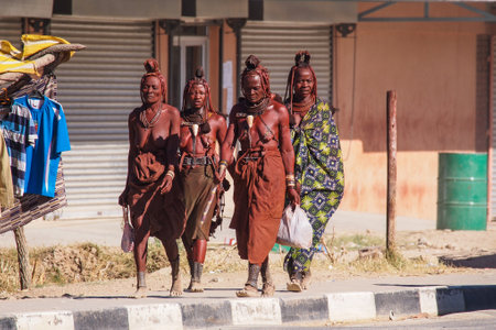 Opuwo, Namibia - Jul 07, 2019: Unidentified Himba women with the typical necklace and hairstyle in the streets of Opuwoのeditorial素材