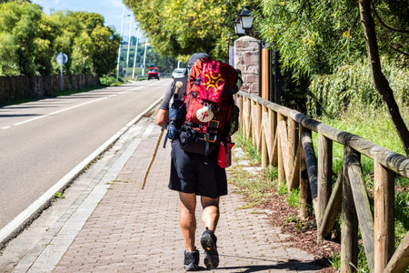 Pilgrim walking towards San Vicente de la Barquera. Way of St. James, Cantabria, Spain. Man...