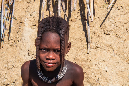 Opuwo, Namibia - Jul 07, 2019: Young unidentified Himba infant in a himba tribe villageのeditorial素材
