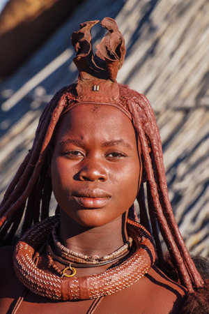 Opuwo, Namibia - Jul 08, 2019: Unidentified Himba woman with the typical necklace and hairstyle in himba tribe villageのeditorial素材