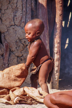 Opuwo, Namibia - Jul 07, 2019: Young unidentified Himba infant in a himba tribe villageのeditorial素材