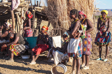 Opuwo, Namibia - Jul 07, 2019: Unidentified Himba women with the typical necklace and hairstyle in...