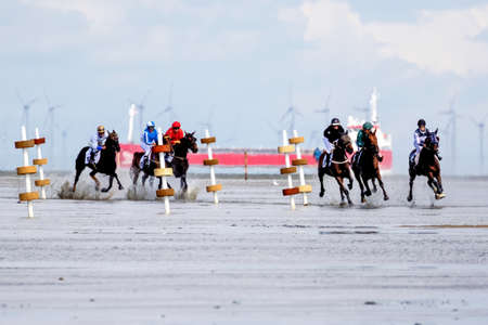 Cuxhaven, Germany - Aug 25, 2019: equestrian at the horse race in the mud flat at Duhner Wattrennen in Germanyのeditorial素材