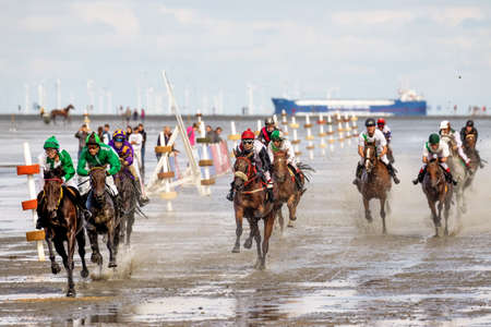 Cuxhaven, Germany - Aug 25, 2019: equestrian at the horse race in the mud flat at Duhner Wattrennen in Germanyのeditorial素材