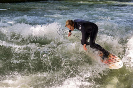 Munich, Germany - July 13, 2019: Surfer in the city river, Munich is famous for people surfing in urban enviroment called Eisbachのeditorial素材