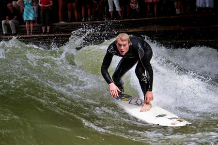 Munich, Germany - Jun 13, 2021: Surfer in the city river, Munich is famous for people surfing in...
