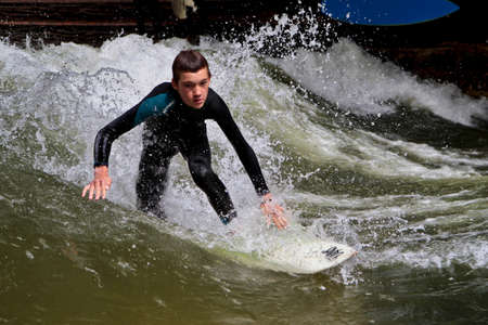 Munich, Germany - Jun 13, 2021: Surfer in the city river, Munich is famous for people surfing in...
