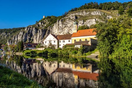 Idyllic sunset view with reflections of Markt Essing with the ruin of Randeck castle over the river Altmuehl in Bavaria, Germanyの写真素材