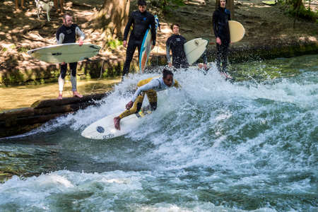 Munich, Germany - July 13, 2021: Surfer in the city river, Munich is famous for people surfing in...