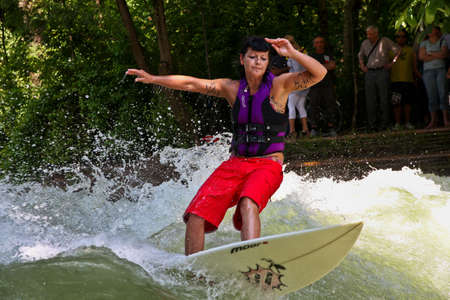 Munich, Germany - July 13, 2021: Surfer in the city river, Munich is famous for people surfing in...