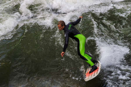 Munich, Germany - October 13, 2021: Surfer in the city river, Munich is famous for people surfing in...