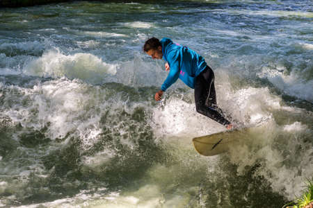 Munich, Germany - July 13, 2021: Surfer in the city river, Munich is famous for people surfing in...