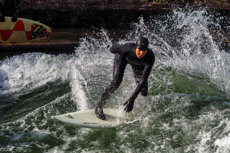 Munich, Germany - December 13, 2021: Winter Surfer in the city river, Munich is famous for people...