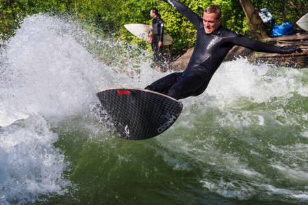 Munich, Germany - July 13, 2021: Surfer in the city river, Munich is famous for people surfing in...