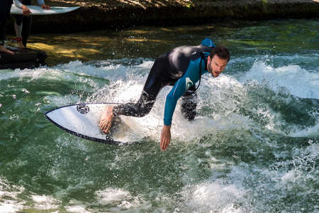 Munich, Germany - Jun 04, 2022: Surfer in the city river, Munich is famous for people surfing in urban environment called Eisbachのeditorial素材