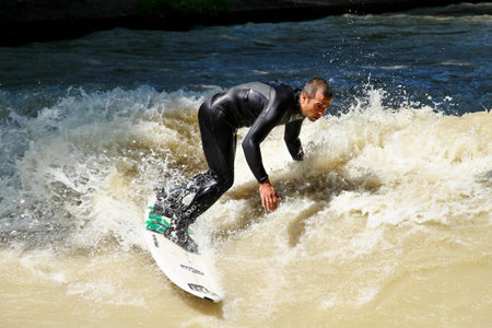Munich, Germany - Jun 04, 2022: Surfer in the city river, Munich is famous for people surfing in urban environment called Eisbachのeditorial素材