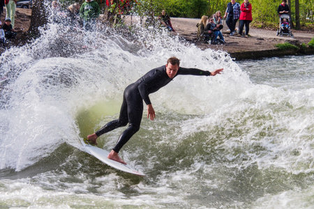 Munich, Germany - Jun 04, 2022: Surfer in the city river, Munich is famous for people surfing in urban enviroment called Eisbachのeditorial素材