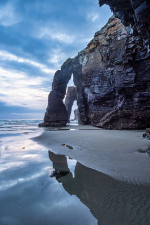 Natural rock arches Cathedrals beach, Playa de las catedrales at Ribadeo, Galicia, Spain. Famous beach in Northern Spain Atlantic. Natural rock arch on Cathedrals beach in low tide.の写真素材