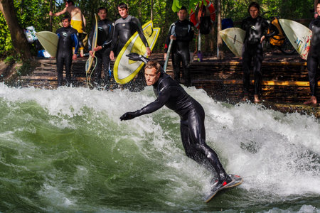 Munich, Germany - Jun 04, 2022: Surfer in the city river, Munich is famous for people surfing in urban enviroment called Eisbachのeditorial素材