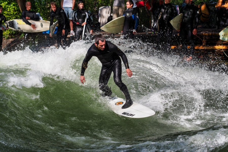 Munich, Germany - Jun 04, 2022: Surfer in the city river, Munich is famous for people surfing in urban enviroment called Eisbachのeditorial素材