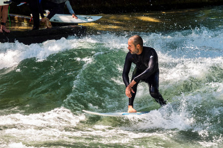 Munich, Germany - Jun 04, 2022: Surfer in the city river, Munich is famous for people surfing in urban enviroment called Eisbachのeditorial素材