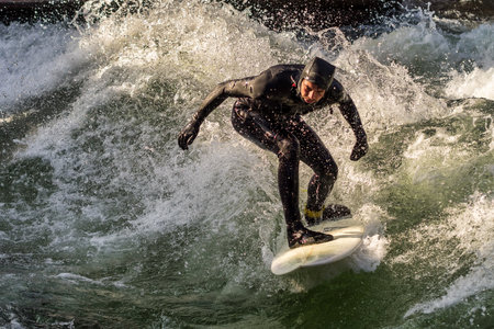 Munich, Germany - December 13, 2022: Winter Surfer in the city river, Munich is famous for people surfing in urban enviroment called Eisbachのeditorial素材