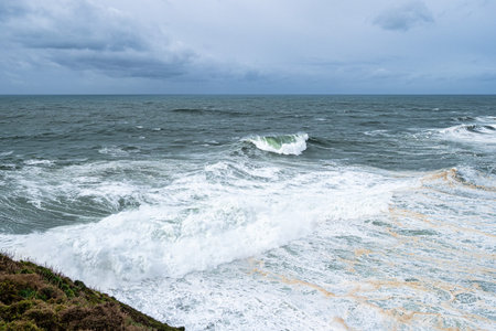 Big waves near the lighthouse at Praia do Norte, Nazare in Portugalの写真素材