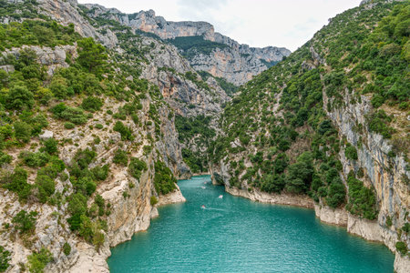 Tourists enjoying turquoise waters of the Verdon Gorge River in France, paddling pedal boats and kayaks on a sunny summer dayの写真素材