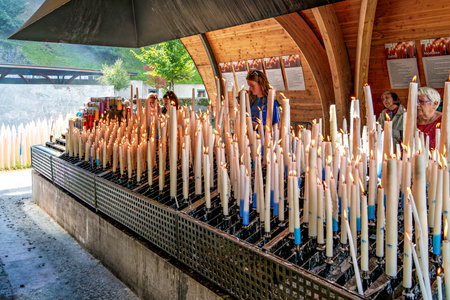 Lourdes, France - Sep 28, 2025: Specially crafted candles burning in Lourdes. One of the great traditions of Lourdes is to light a candle in front of the Grotto.のeditorial素材