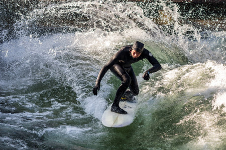 Munich, Germany - December 13, 2024: Winter Surfer in the city river, Munich is famous for people...