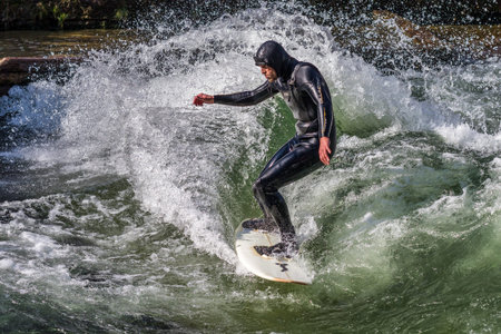 Munich, Germany - December 13, 2024: Winter Surfer in the city river, Munich is famous for people...