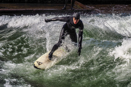 Munich, Germany - December 13, 2024: Winter Surfer in the city river, Munich is famous for people...