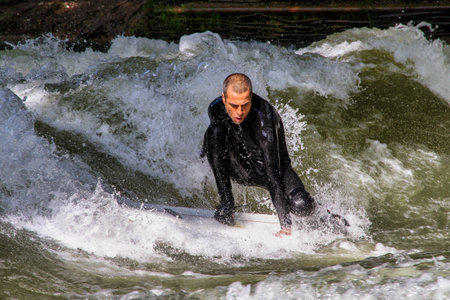 Munich, Germany - Jun 04, 2024: Surfer in the city river, Munich is famous for people surfing in...
