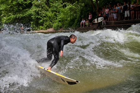 Munich, Germany - Jun 04, 2024: Surfer in the city river, Munich is famous for people surfing in...