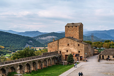 Ainsa, Spain - Oct 19, 2025: Ainsa Castle in the medieval village of Ainsa in Spain surrounded by stone walls with an elevated path leading to it. Region of El Sobrarbeのeditorial素材