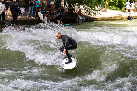 Munich, Germany - Jul 26, 2024: Surfer in the city river, Munich is famous for people surfing in...