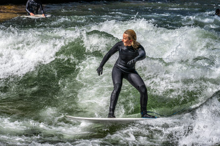 Munich, Germany - Apr 12, 2025: Surfer in the city river, Munich is famous for people surfing in...