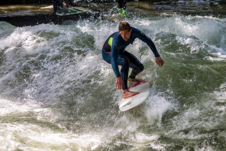 Munich, Germany - Jun 04, 2024: Surfer in the city river, Munich is famous for people surfing in...