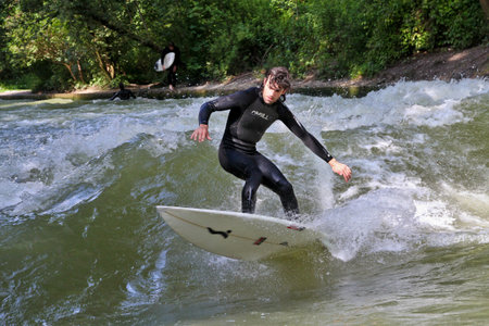 Munich, Germany - Jun 04, 2024: Surfer in the city river, Munich is famous for people surfing in...