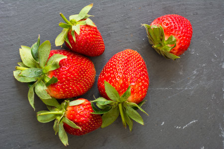 Fresh strawberries on black stone background. Top view with copy space.の写真素材