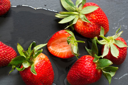 six fresh red strawberries with water on neutral background, top view, close-upの写真素材