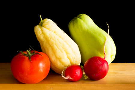different and colorful vegetables on a wooden table, on black background.の写真素材