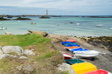Colorful boats and lighthouse on the coast of Brittany, Plouguerneau, with Phare de la Vierge.の写真素材