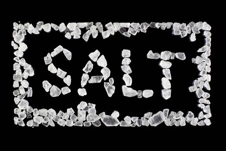 Framed SALT inscription created from salt crystals on black background close up