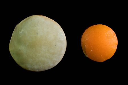 Macro of uncooked single red lentil grain and green lentil grain isolated on black backgroundの写真素材