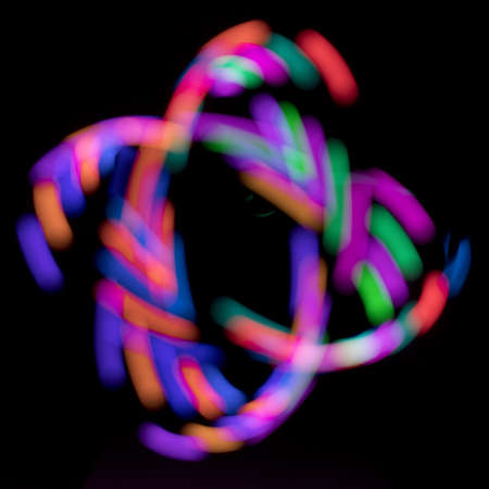 Abstract rainbow path of moving LED light on black backgroungの写真素材
