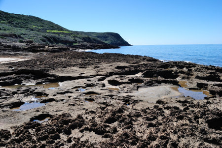 Rocky coast of the island of Sardinia, under tower Ischia Rujaの写真素材