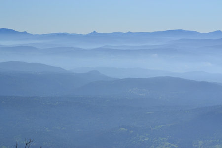 View from the top of the mountain to the valley covered with fog
