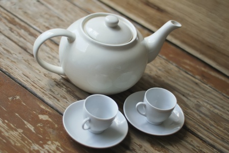 Traditional teapot and two cups set on a wooden tableの写真素材